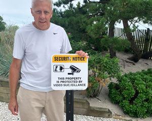 Property protected by remotely monitored security services sign
