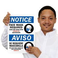 Bilingual sign requiring face mask even with vaccination